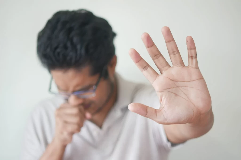 A man is coughing at home due to high amount of formaldehyde at home.